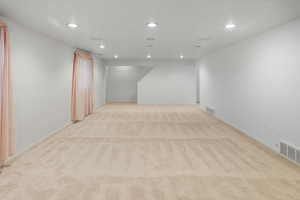 Room with recessed lighting and light colored carpet