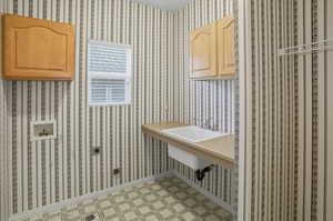 Laundry room with wallpapered walls and hookup for a washing machine