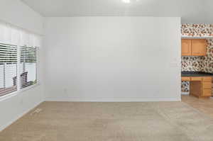 Spare room featuring built in study area and light carpet