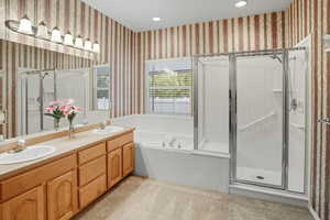Full bath featuring light colored carpet, wallpapered walls, double vanity, a shower stall, and recessed lighting