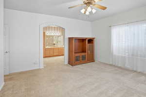 Room featuring light colored carpet and a ceiling fan