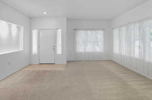 Foyer with carpet and baseboards