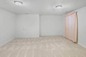 Room with a textured ceiling and light carpet