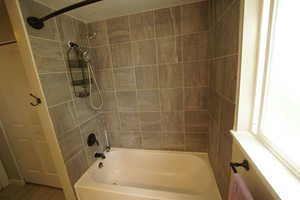 Full bathroom with shower / bathtub combination, a textured ceiling, and wood finished floors