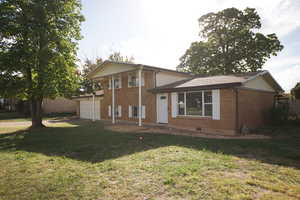 Split level home with brick siding and a front yard