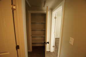 Hall featuring dark carpet and baseboards