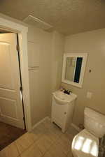 Bathroom featuring vanity, a textured ceiling, and light tile patterned floors