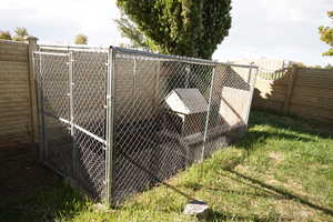 Gate with a fenced backyard, an outbuilding, and exterior structure