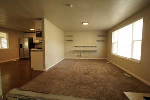 Unfurnished living room featuring a textured ceiling