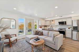 Living area with light wood-style flooring and recessed lighting
