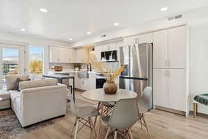 Kitchen with stainless steel appliances, recessed lighting, backsplash, light wood finished floors, and open floor plan