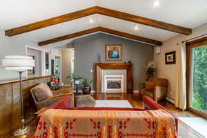 Living room with a fireplace, recessed lighting, wood finished floors