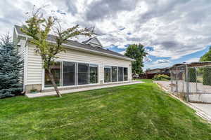 Rear view of property with a sunroom with pool.