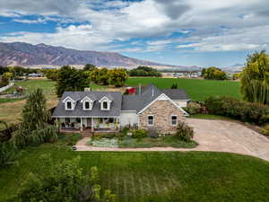 View of front of property featuring a covered porch, a front yard, a mountain view, and concrete driveway