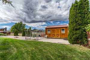 View of yard featuring an outbuilding, a patio, and an exterior structure