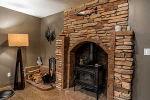 Detailed view of a wood stove, carpet, and a textured ceiling