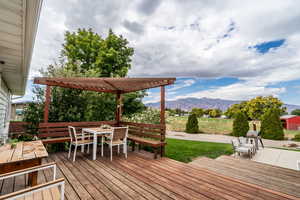 Wooden terrace featuring outdoor dining space and a mountain view