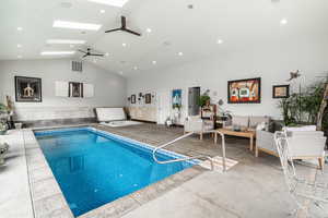 Indoor pool with a skylight and ceiling fan