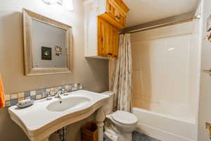 Bathroom featuring shower / bath combination with curtain and toilet