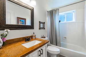 Bathroom with shower / bathtub combination with curtain and vanity