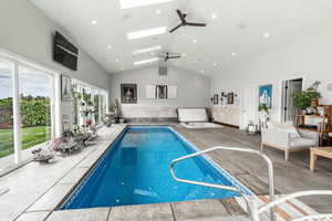 Indoor pool featuring a skylight and ceiling fan