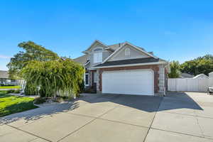 Traditional-style home with brick siding, driveway, roof with shingles, and a garage