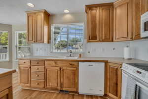Kitchen with white appliances, light countertops, backsplash, plenty of natural light, and recessed lighting