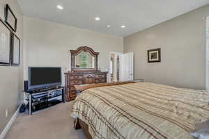 Master bedroom featuring recessed lighting and light carpet