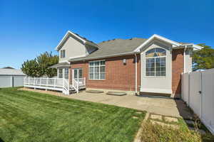 Back of property with a patio area, brick siding, and a deck