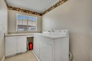 Laundry room featuring light tile patterned floors and washer and dryer