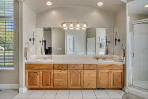 Master bathroom with double vanity, a stall shower, recessed lighting, and light tile patterned flooring