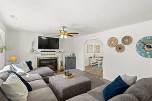 Living room featuring a tile fireplace and arched walkways