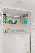 Laundry room featuring independent washer and dryer and a textured ceiling