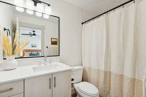 Full bath with vanity, a shower with curtain, and ceiling fan