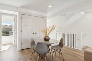 Dining space with light wood-style floors and recessed lighting