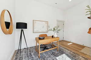 Office space with light wood finished floors and recessed lighting