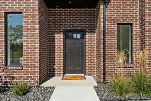 Entrance to property featuring brick siding
