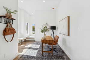 Office space with light wood-style flooring and recessed lighting