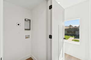 Laundry area with wood finished floors and washer hookup