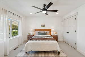 Carpeted bedroom with a closet, a ceiling fan, and recessed lighting