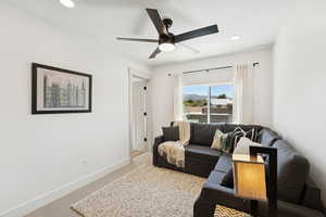 Carpeted living room featuring recessed lighting and ceiling fan