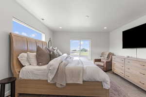 Primary bedroom featuring multiple windows, carpet flooring, and recessed lighting