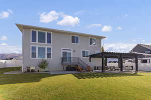 Rear view of house featuring a patio area, stucco siding, and a pergola