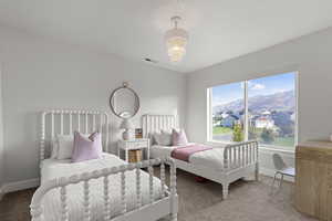 Carpeted bedroom featuring a mountain view, a residential view, and a chandelier