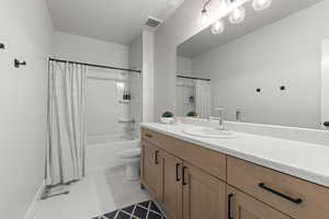 Full bath featuring shower / bath combination with curtain, vanity, and light tile patterned floors