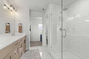 Bathroom with a stall shower, vanity, and light tile patterned floors