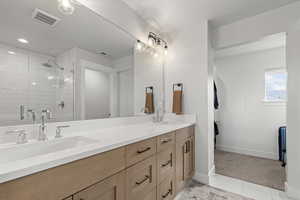 Bathroom featuring double vanity, a shower stall, and recessed lighting