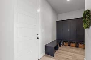 Mudroom with light wood-style floors and baseboards