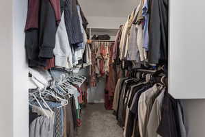 Walk in closet with dark carpet