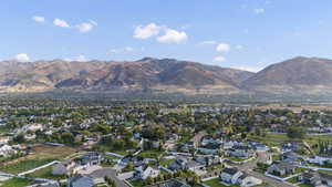 Aerial view of property and surrounding area with nearby suburban area and a mountainous background